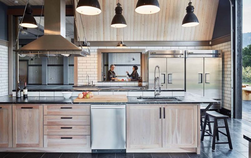 The commercial kitchen features industrial pendant lamps imported from Europe, a professional wood burning Mugnaini pizza oven, Perlick refrigerator drawers, wine and beverage coolers.