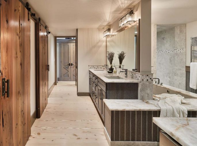 The master bathroom features rare quartz slab countertops, dark stained oak cabinets, with white glaze beadboard and hydronic heated floors.