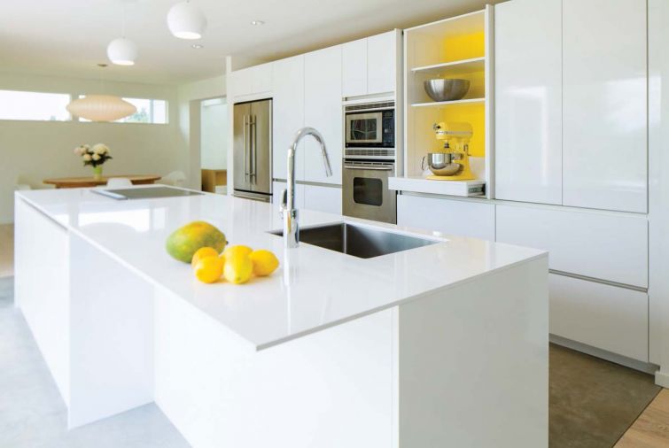 Homeowner Michaela Spaeth wanted to see a “happy” yellow color inside the central cabinet, and SieMatic had just introduced a signature yellow lacquer accent color that matches her KitchenAid perfectly.