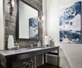 The powder room located off the entry features an industrial steel table, Caeserstone quartz countertop and a marble zebra vein wall tile, with contrasting polished nickel Decor Walther sconces.