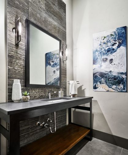 The powder room located off the entry features an industrial steel table, Caeserstone quartz countertop and a marble zebra vein wall tile, with contrasting polished nickel Decor Walther sconces.