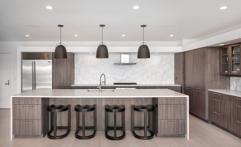 Veneer-clad cabinets and Haleigh Wire Dome Rod pendants from Rejuvenation contrast with the 3-D backsplash by Modular Arts.