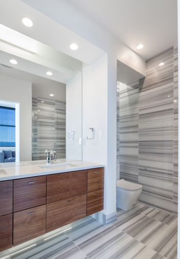 Linear marble tiling from Oregon Tile and Marble gives the bathroom its eye-catching graphic design.