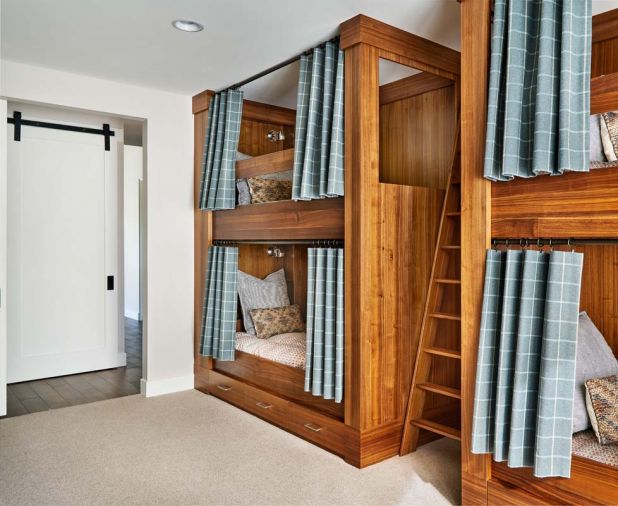 Curtains enable children to get better rest; LED lights make easy reading; plug-ins charge electronics. Bottom bunks feature storage. Laundry behind sliding barn door.