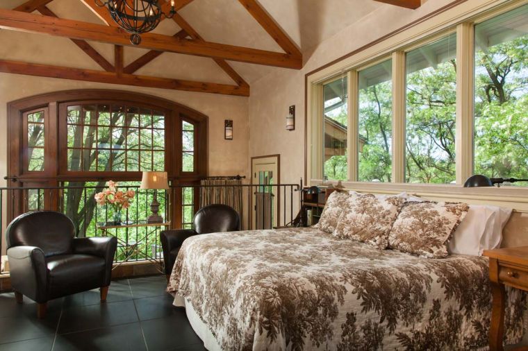 Abeja's Edison House loft-style cottage's master bedroom sits up half a story, where the branches of the trees feel within reach.