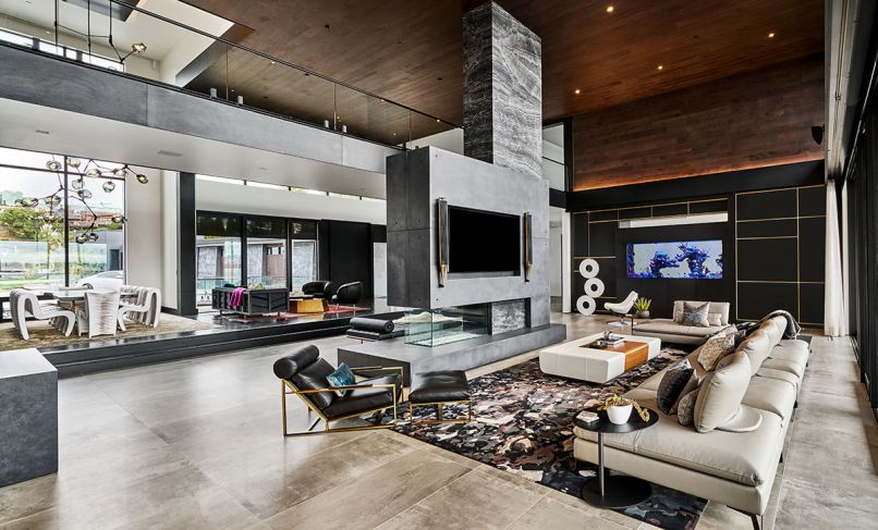 A fireplace cantilevers dramatically off a structural marble pillar and concrete base. Roche Bobois Scenario sectional. Holly Hunt Oasis Cocktail Ottoman.