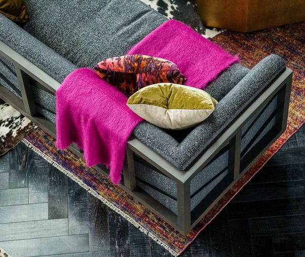 A hot pink throw pops against custom fabric on an Arteriors sofa.