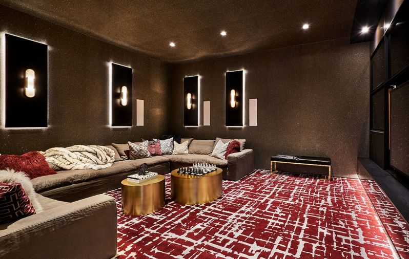 A Cloud sectional in performance linen by Restoration Hardware Modern adds comfort to the theater experience. Luxurious gray and oxblood jewel tone custom wall-to-wall Davis & Davis carpet adds plushness underfoot. Thayer Coggin Design Classic golden drum tables add sparkle.