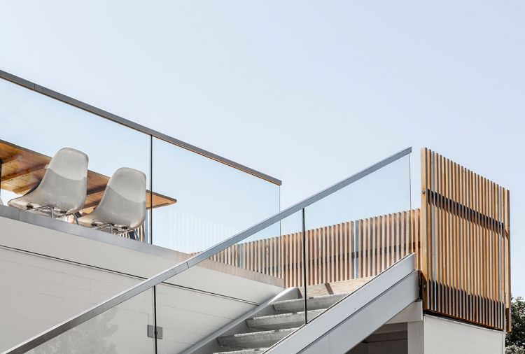 Steel stringer stairs with a cantilevered glass guardrail and precast concrete treads provide access to the deck while preserving the view.