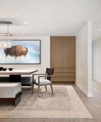 In the dining room, focal point artwork by Aaron Hexom depicting a buffalo—an animal that has special significance to the family—adds an ethereal quality, and a crystal droplet light from Bone Simple is a decorative touch. Rug from Stacey Logan.
