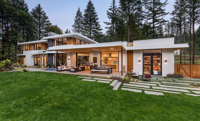 The clients, who work nearby, requested a modern home with simple, clean lines to fit within the heavily forested 1.2-acre site and to embrace outdoor living throughout the year. They requested the home to be truly livable in the cool northwest climate with natural daylight and filtered views of the forest. Indoor/outdoor living is emphasized throughout the design. A protected acid-washed concrete terrace is furnished with Restoration Hardware seating, a Marbella Metal Rectangular table.