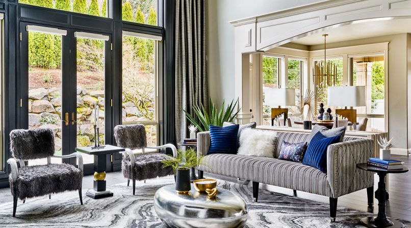 To open up the living areas, heavy traditional elements were eliminated, including quadruple crown moldings, massive Roman columns that blocked passageway from the living area to dining nook. Edgy fur chairs with bone pair with pinstriped velvet sofa.