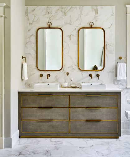 Charlie Zagaroli’s Cela Shagreen Fog Double Vanity from Restoration Hardware features burnished brass trim. A pair of Renwil mirrors continue the brass theme set here against the Z Collection Calacatta Oro tile as backsplash. Brass wall mounted Delta Trinsic faucets and Lacava Cube Lav sinks complete the look.