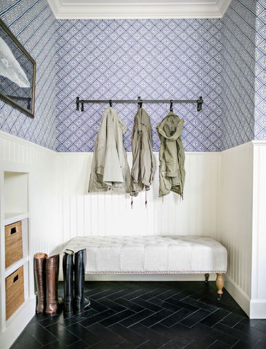 In the mudroom, gloves and hats can be stashed in woven storage bins, boots can be removed while sitting on an upholstered bench, and coats can be hung on a series of convenient hooks.