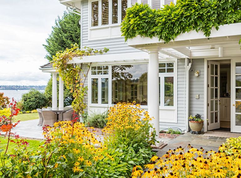 The home’s entrance, contrary to most lakeside homes, faces the water, embraced by a golden-hued garden.