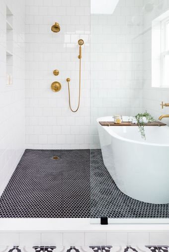 Black hex floor tiles add dramatic contrast to serene corner of master bath. Kohler Purist matte brass tub filler and fixtures echo kitchen sink hardware. Luxurious 70' Signature Hardware tub stands away from wall for easy cleaning.