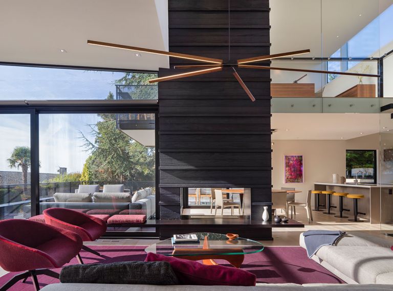 Elizabeth Stretch of Stretch Design chose vital colors to enliven the living space: burgundy rug; fuchsia furnishings pop against Shou Sugi Ban fireplace.