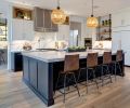 he kitchen, conveniently located off the main living area, features a custom range hood with metal strappings, Wolf range, steam oven, convection oven, 48  Sub-Zero refrigerator, Quoizel pendants, and Four Hands Diaw bar stools in Havana. 
Photograph © Jesse Prentice