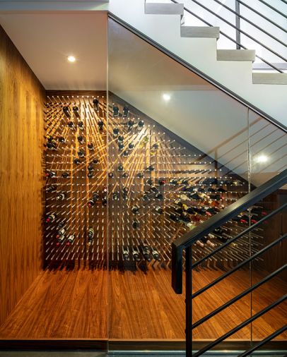 aneled glassed-in wine cellar nestles beneath entry staircase, with raised walnut floor and imported pegs.