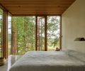In the bedroom, glass walls frame picturesque views of the preserved trees.