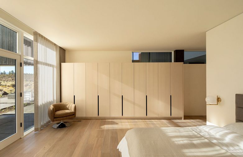 Finely detailed primary bedroom cabinetry features exquisite vertical grain ash.