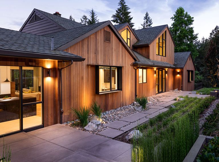 Schouten’s transformed exterior features vertical cedar fine line T&G siding from Lakeside Lumber. Handsome Michael Schultz Landscape Design draws eye to newly designed roof, windows, and dramatic entry illuminated by Oregon Outdoor Lighting.
