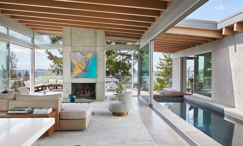 Fleetwood doors and windows throughout are from Goldfinch, and foster a fluid connection between inside and out, with glass panels even pocketing into the concrete fireplace column. Outdoor sofas, coffee table, table and benches are from Janus et Cie.