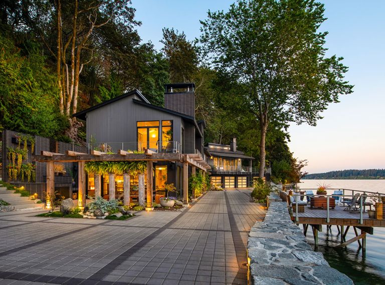 This 6,880-square-foot Bremerton home was remodeled in 2023. The architects redesigned the driveway with Park Permeare in pewter with charcoal accents from Western Interlock Inc. to give it more character. Exterior lighting provided by Northwest Outdoor Lighting.