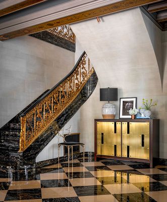 Missing c. 1922 bronze “S” railing was recast for Potoro marble staircase. Dingy walls refreshed with limewash plaster by Studio C. Stunning brass Necchi sideboard from Natasha Baradaran. Uteki painted lamp from Anthropologie and bronze Amsterdam Chair from Magni Home Collection.