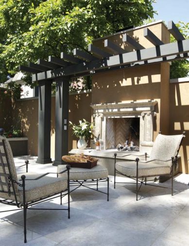 The outdoor gas fireplace is handsomely offset by a dark espresso stained arbor that reiterates the espresso colored stucco from the nearby pool.
