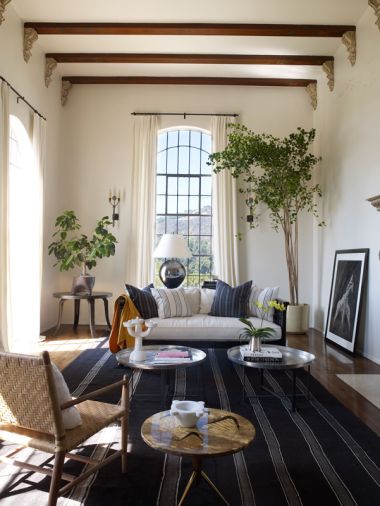 Martyn Lawrence Bullard’s historic Hollywood villa for actress Ellen Pompeo and Chris Ivery. The living room ceiling soars to eighteen feet, with impressive metal framed windows. A vintage Afghan rug from Amadi Carpets fills the floor, while Moroccan tea tables from Caravane Chambre 19 in Paris mix well with a 1950s Osvaldo Borsani lacquered vellum-topped side table.
