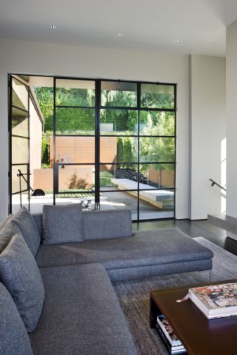 The rectangular configuration of the steel-framed windows is reinforced by the shapes of the hardscape viewed through the panes.