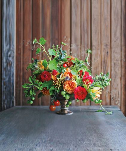 Garden of Eden: Edibles can add spice, texture and pops of unexpected color to arrangements. Shown is a mixture of scented geraniums, viburnum berries, nasturtiums, tomatoes, garden roses, baby apples, berries, crabapples, and grasses.