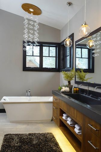 'The homeowner wanted a hanging bubble light fixture over the bath tub,' the designer explained. 'The electrical code prevents you from hanging a fixture over a tub. I designed the faux - fixture to look like the bubble light. It is actually a recessed ceiling light with a teak trim piece with hanging globes.'