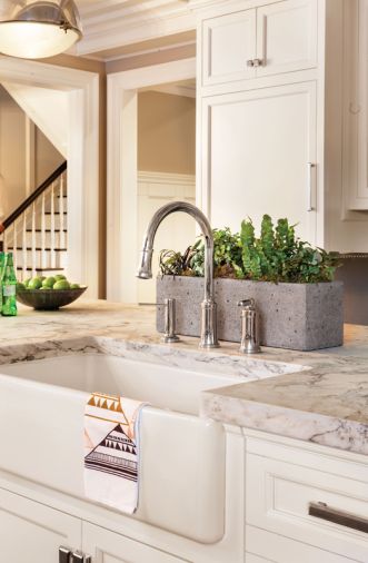 A handy 36' farmhouse sink is paired with a Kallista 'Quincy' Nickel faucet for food prep.