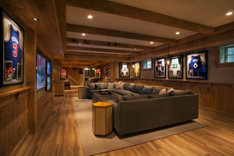 Rough sawn oak walls feature basketball memorabilia in the basement. Spacious seating, and multiple TV screens promote casual entertaining. Highly resistant porcelain plank flooring resembles wood.