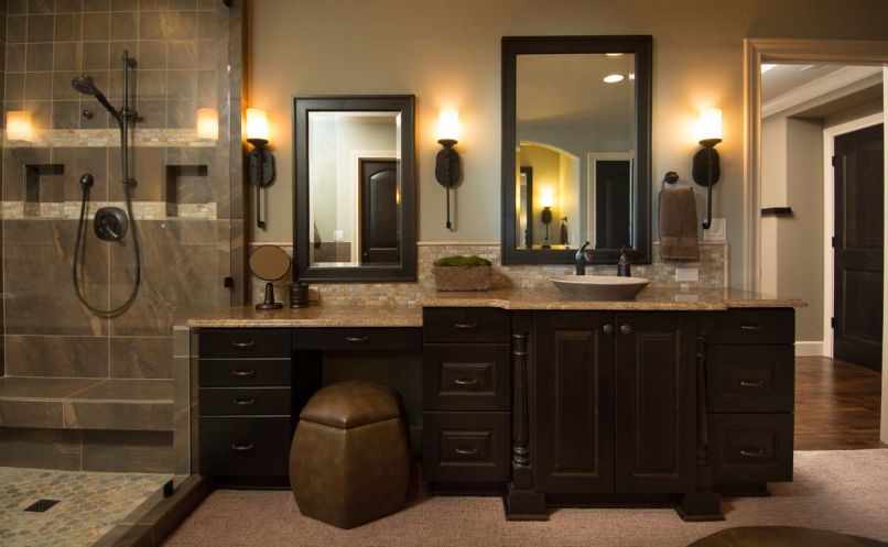 In the bathroom, cabinet design and granite counters are repeated from downstairs and Kohler sinks are mated with Delta faucets. To provide plushness under foot, the homeowner requested the floor be carpeted.