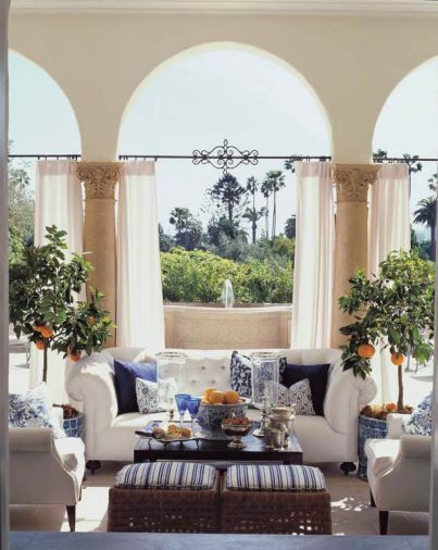 Iron rods were custom-made to hang atmospheric curtains on the back loggia of the Buster Keaton estate, which has English-style furniture upholstered in white canvas and blue-and-white Ralph Lauren fabrics.