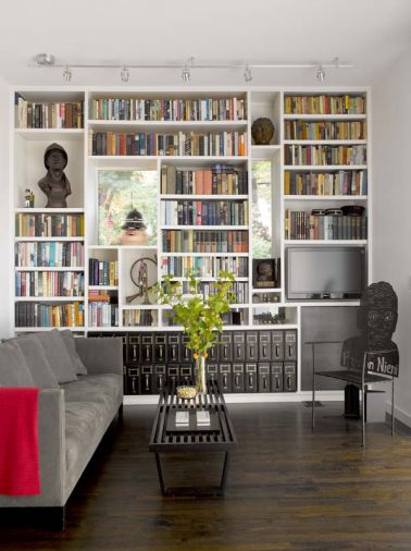 The library provides an intimate space in which to read or watch TV. A portrait chair by the owner’s stepson immortalizes her late husband. Like the dining and living rooms, the library opens to the walled back yard and pool.