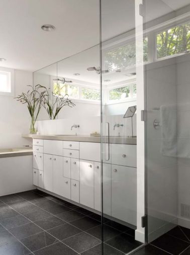 A mirror running the width of the wall above the sinks reflects light into the master bath.