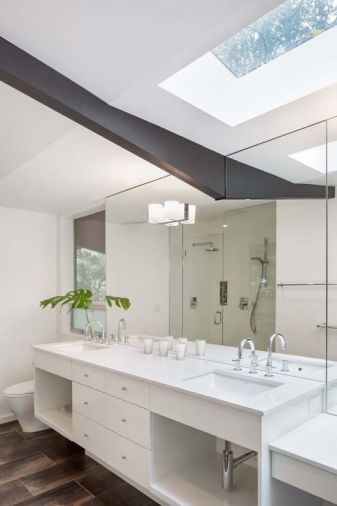A skylight was added to visually lift the roof in the master bath. Custom vanity was treated to a durable automotive finish technique.