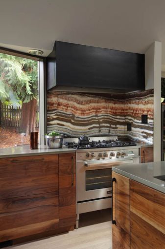 A granite backsplash ties together the tones in the kitchen with the hues seen outside. Drawers by the range provide storage for herbs and spices. Designer and homeowner Christina Tello believes in form following function, which her husband took to heart when he gave her the tree branch salt and pepper shakers.