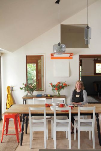 The dining area of the remodeled kitchen is so successful that the couple turned the home’s formal dining room into a library. A wall-hung orange paper cutter holds a roll of paper for children’s artwork or for adults’ games of Pictionary. The table and chairs are from Ikea while the orange stool is from Wayfair. Often the hub of all activities, the kitchen was designed with enough open space for family and guests to congregate and socialize.