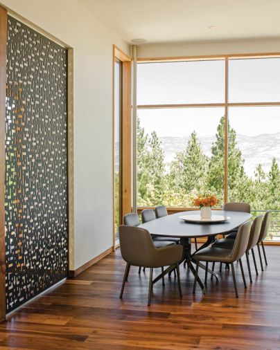 A Minotti Claydon dining table and Flavin chairs outfit the dining room, which captures sweeping mountain views.