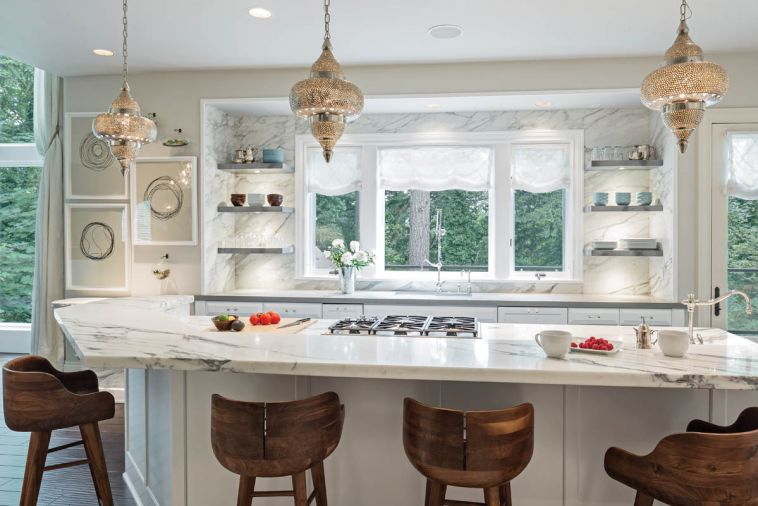 The kitchen was transformed by a refresh rather than a remodel; both the appliances and the footprint were retained by the homeowners. The only structural change introduced by Baines was to remove the upper cabinets that flanked the kitchen window. In their place, a new marble backsplash extends up the wall from the counter to the ceiling.