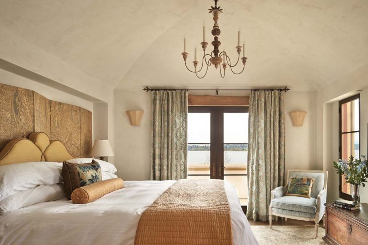 Cast stone sconces in the master add authentic ambiance; headboard and screen design by Hyde Evans.