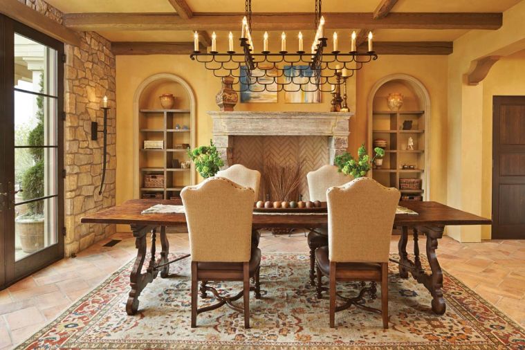 The dining room chandelier was designed by Hyde Evans, based on an antique. Sconce by Woodland Furniture. Antique stone fireplace from Chateau Domingue in Houston.