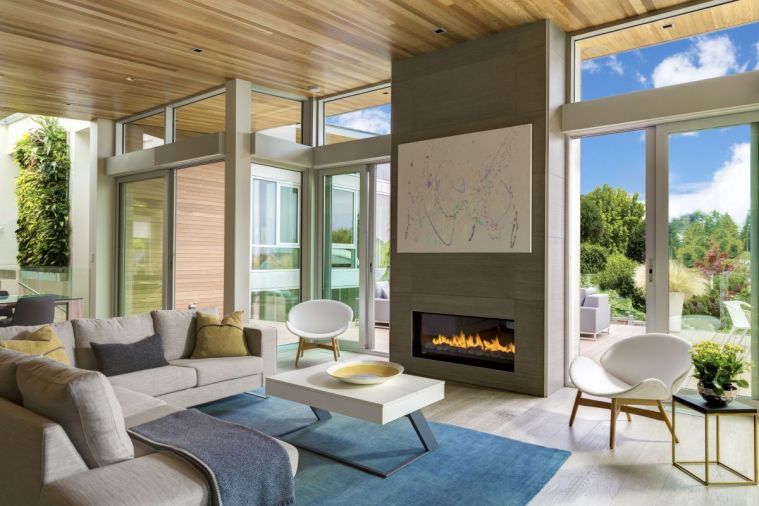 A soaring porcelain Italian tile fireplace parallels custom sliding glass doors leading to the deck. An art lift featuring their child’s artwork reveals and hides TV.