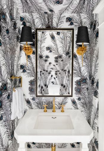 Brass and a vertically patterned peacock wallcovering in black, white and a touch of turquoise enliven a diminutive powder room.