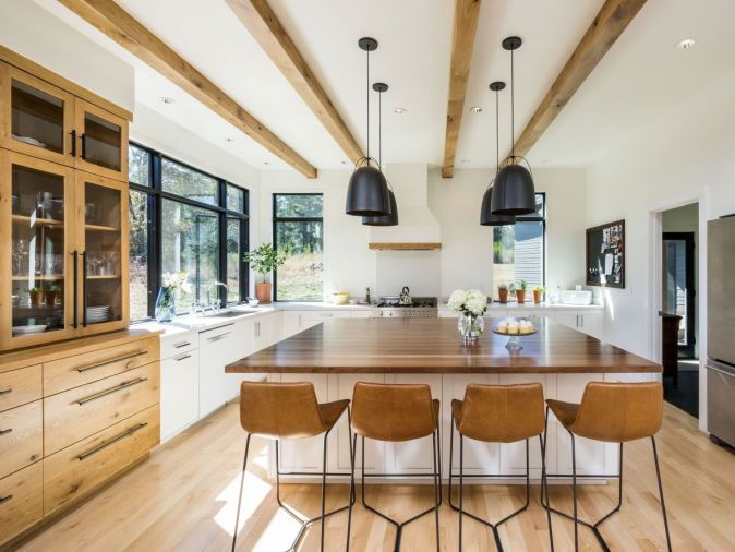 The kitchen artfully blends three different types of wood by balancing multiple textures with clean white walls and an open layout perfect for entertaining. The countertops and backsplash are made from Caesarstone, an engineered quartz that offers easy maintenance and great durability.